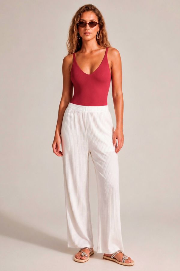 Look d'été : maillot de bain Compressive rouge avec pantalon blanc
