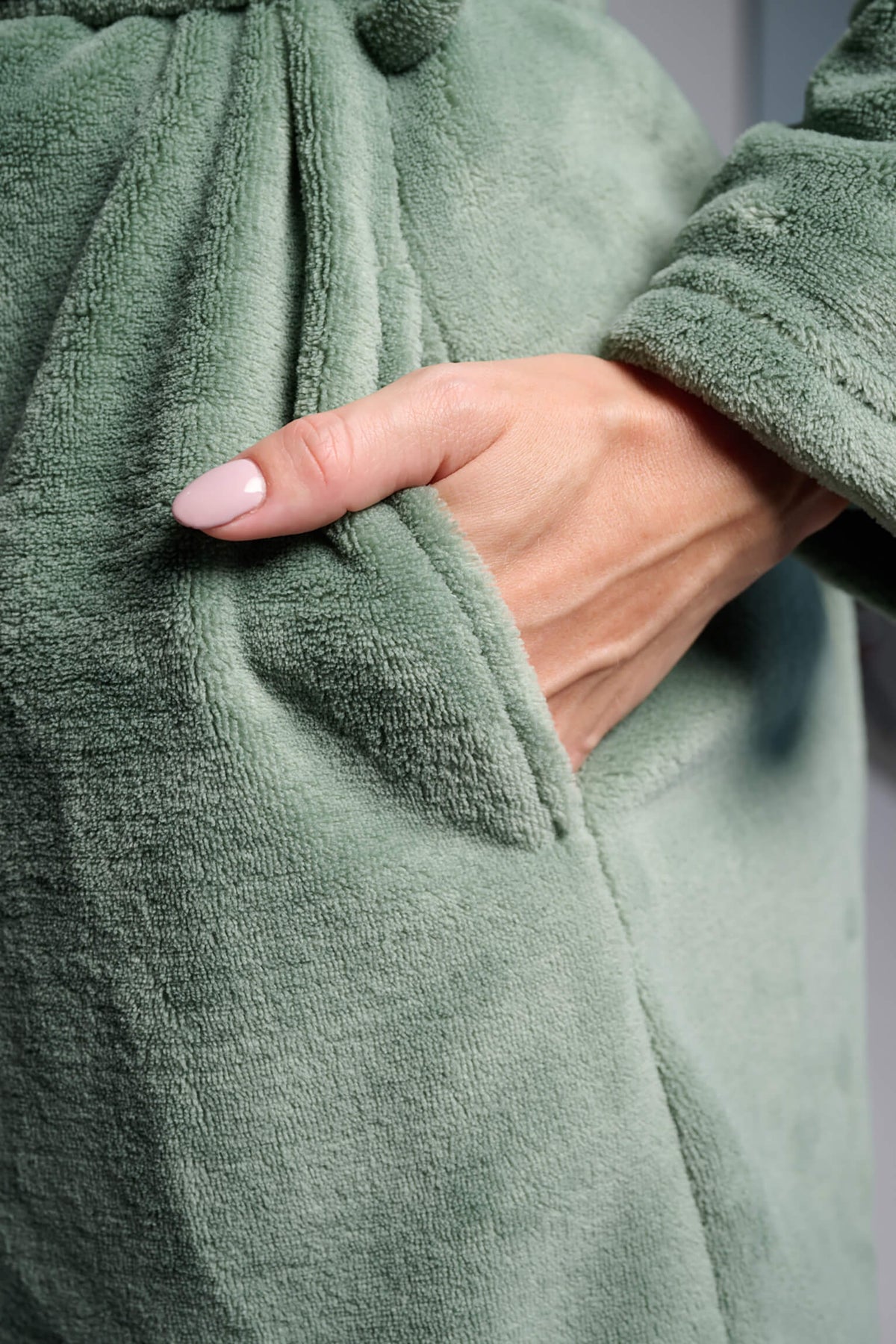 Bata corta de coralina polar verde para mujer con cremallera y cinturón, diseño suave y cómodo para los meses fríos.