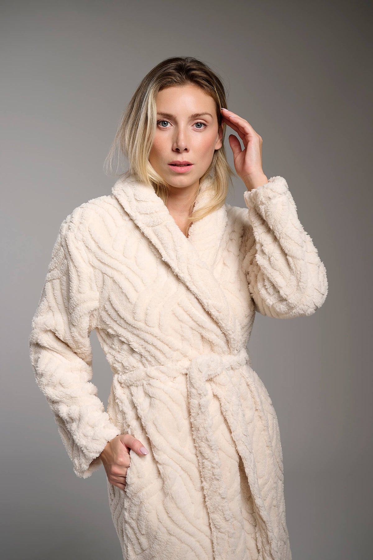 Bata larga polar de borreguito en blanco marfil para mujer con textura, diseño suave y cómodo para los meses fríos.