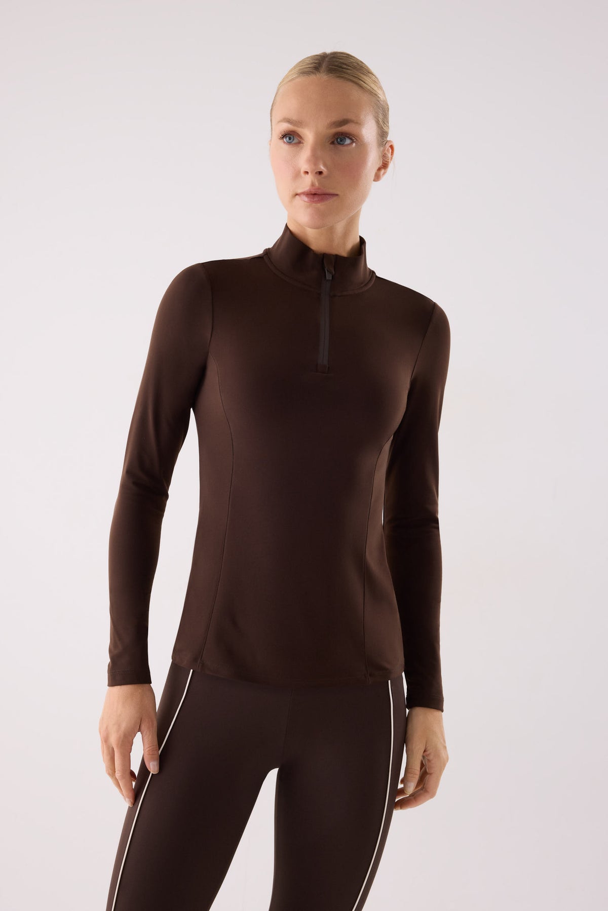 camiseta deportiva manga larga con media cremallera gimnasio en marrón dark chocolate vista principal en look deportivo tejido transpirable con interior afelpado