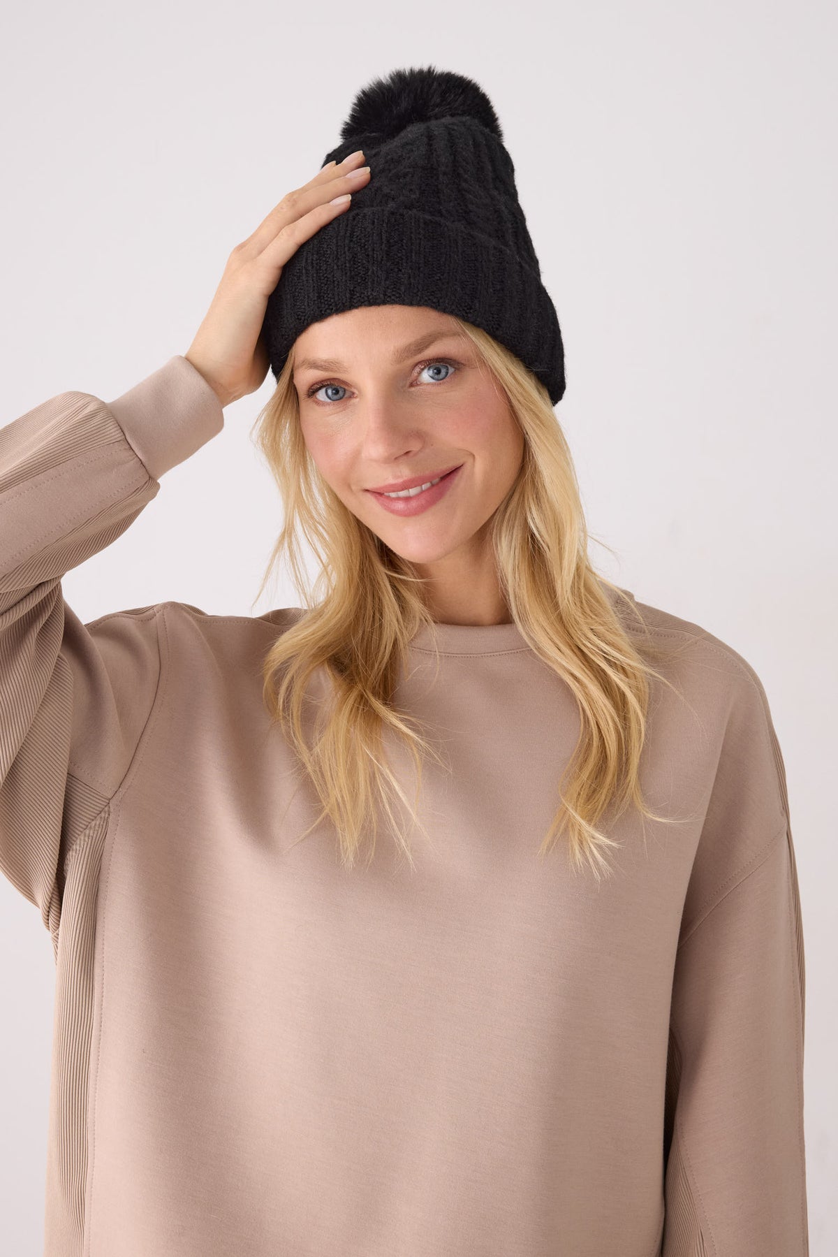Bonnet femme en maille noir à pompon avec doublure polaire